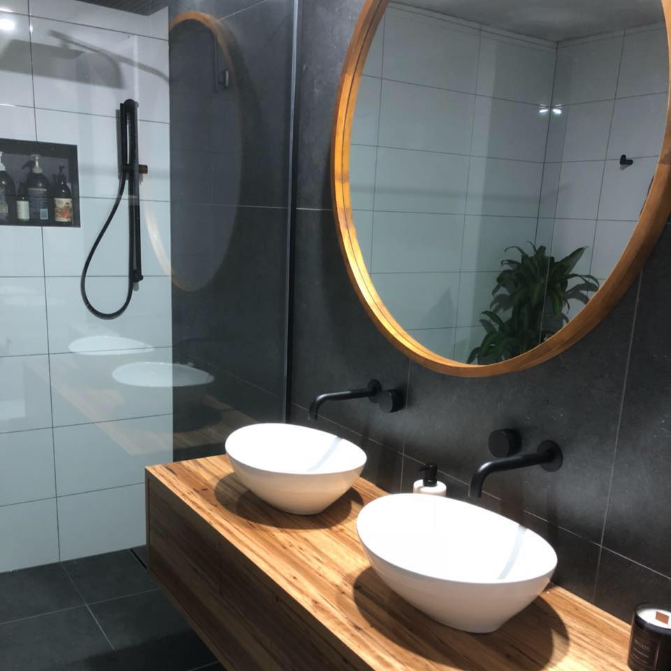 Luxury bathroom renovation with dark tiles and timber floating vanity